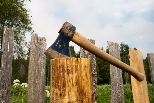 Axe in log after an old wooden fence repair