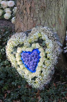 Heart sjhaped sympathy flowers in blue and white