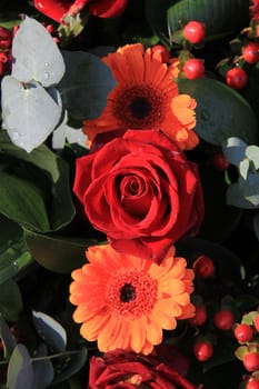 Flower arrangement in red and orange, roses and gerberas