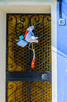 Door with stork colorful houses of Burano, Venice, Italy