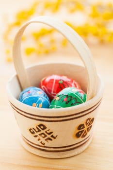 Basket with colored Easter eggs. Vertical view