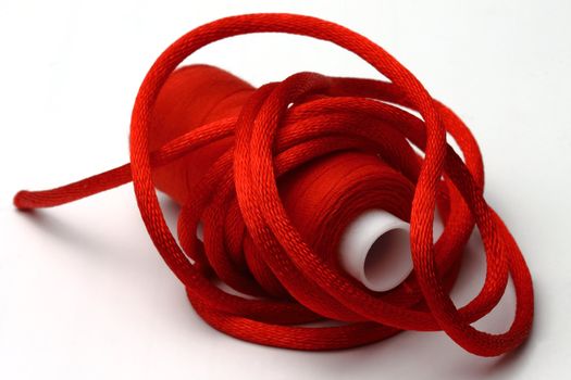 The red coil of threads and red band on a 
white background
