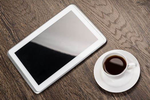 tablet and cup of coffee are on the table, still life