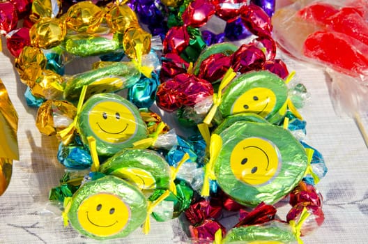 Colorful candies with smiles sold at outdoor street fair market and sunlight.