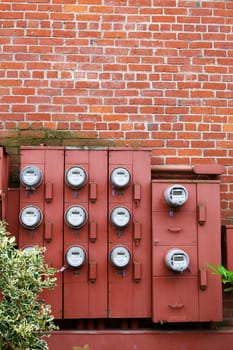 Ten Electric Meters on the red brick wall of an apartment building