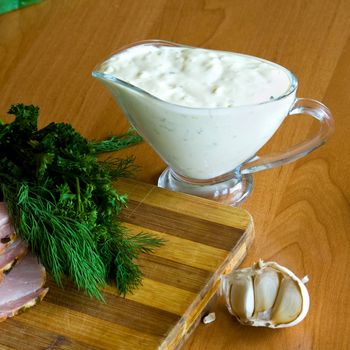 A salad of fresh green vegetables and ham with sauce in glassware 