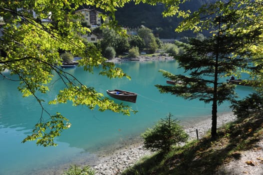 An image of a boat on a blue lake and green trees