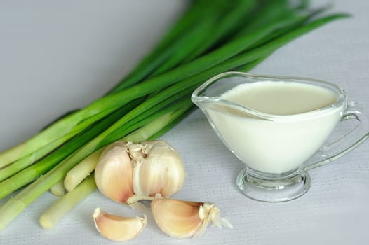 An image of white souce and green onion with garlic