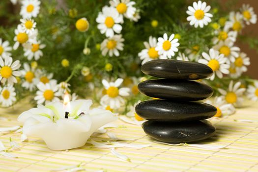 Black stones for spa massage and candle