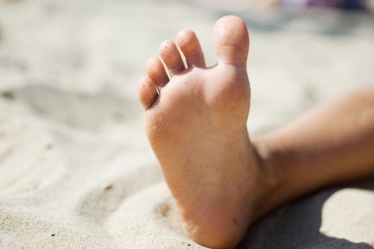 An image of a little foot in the sand