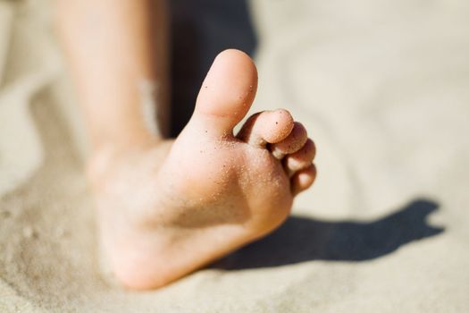 An image of a  little girl's foot in the sand 