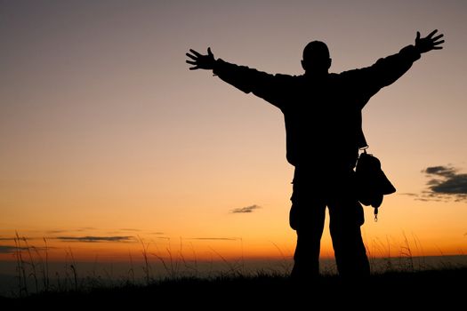 An image of a silhouette of a man on background of sunrise