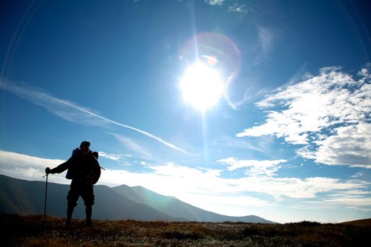 An image of silhouette of a tourist on a hill