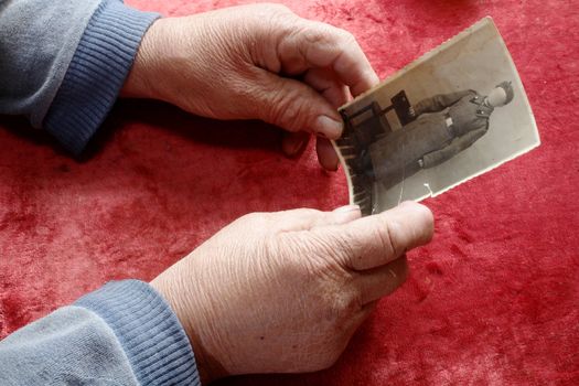 An image of old hands holding old photo 