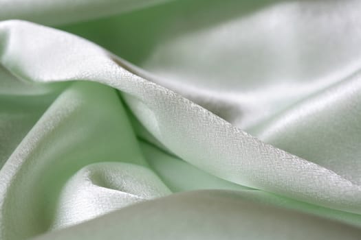 An image of folds of green shine fabric