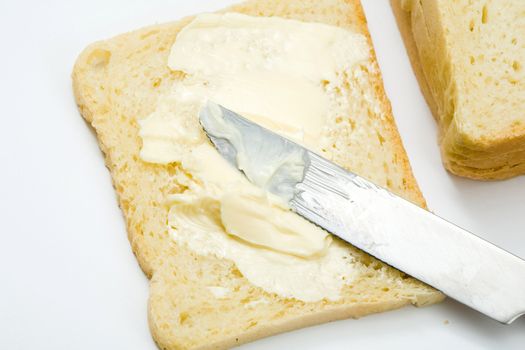 Stock photo: an image of fresh butter on a slice of bread and a knife
