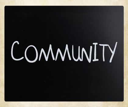 "Community" handwritten with white chalk on a blackboard