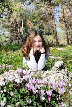 the girl in the forest among flowering cyclamens