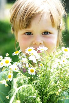 Cute little girl with a bucket of daisies outdoors