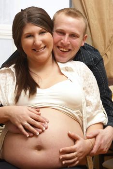 A couple of soon to be parents pose for a happy portrait.
