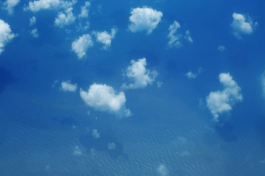 Aerial view on clouds with shads on sea smooth