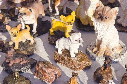 Clay hand-made ceramic dog and cat figurines sell in outdoor street fair market.