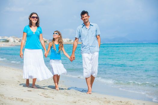 Family of three having fun on tropical beach