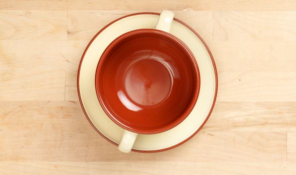 Cup of soup on a plate, wood background