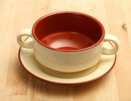 Cup of soup on a plate, wood background