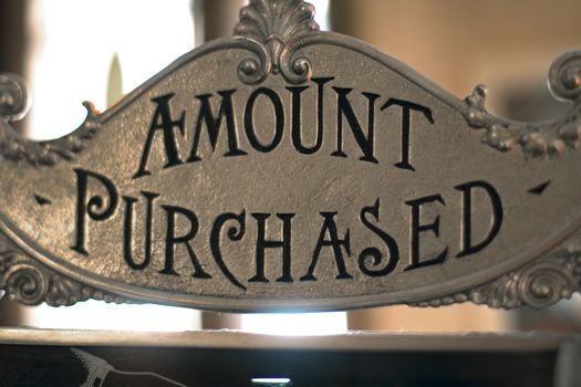 Amount purchased sign on antique brass cash register