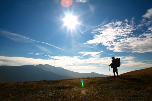 An image of silhouette of a tourist on a hill