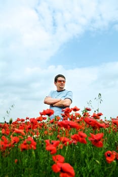 An image of a man in the field with his hands spread