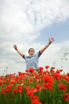 A man in the field with his hands spread