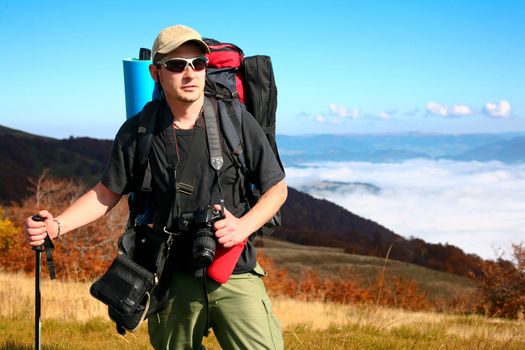 An image of walking photographer in mountains