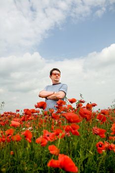 An image of a man in a field with poppies