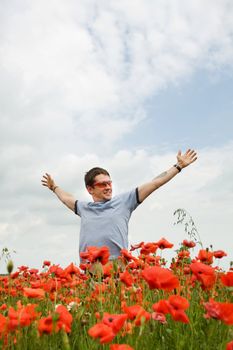 A man in the field with his hands spread