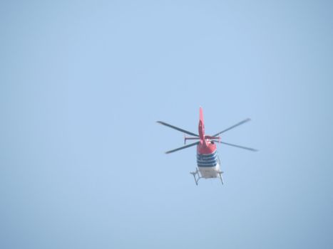 Helicopter flying high in the blue sky