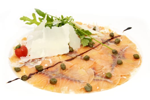 Slices of salmon with herbs and cheese on a white plate