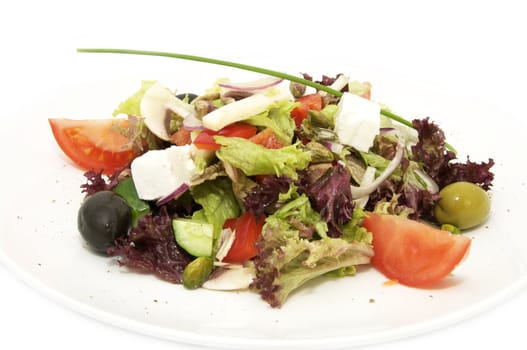 Greek salad with vegetables and cheese on white background
