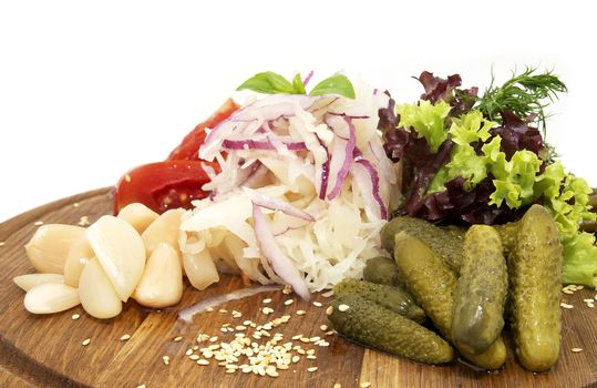 wooden plate of pickles on a white background