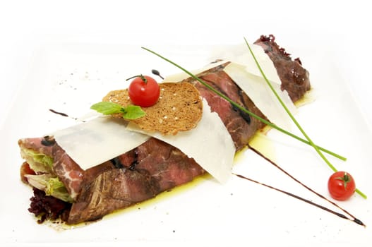 Carpaccio in the form of roll on a white plate