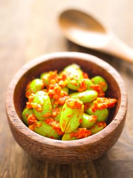 close up of a bowl of petai beans in sambal sauce