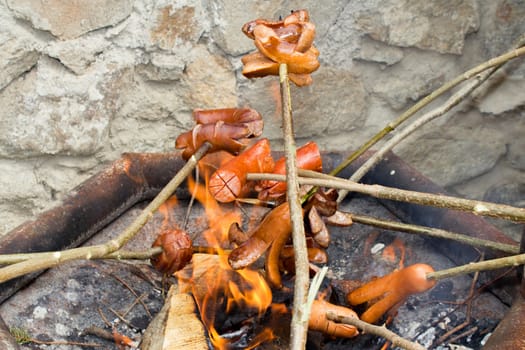 grilling sausages over open fire outdoor