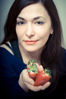 beautiful woman with strawberries on gray background