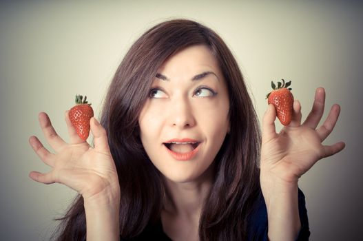 beautiful woman with strawberries on gray background