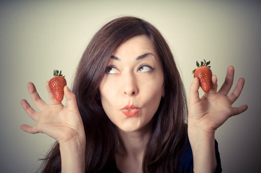 beautiful woman with strawberries on gray background