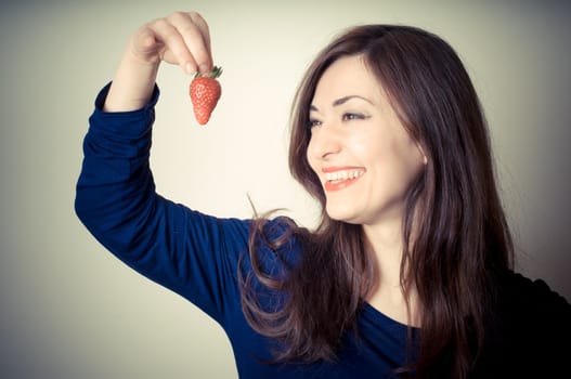 beautiful woman with strawberries on gray background