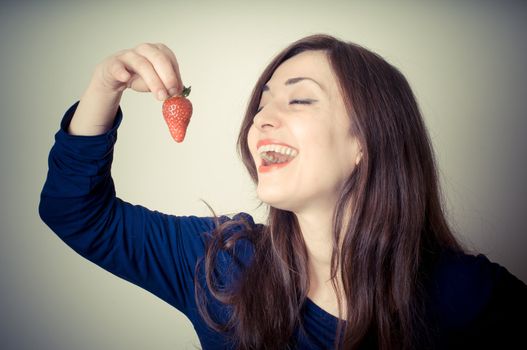 beautiful woman with strawberries on gray background