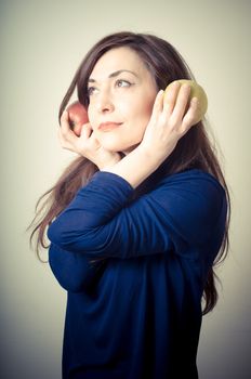 beautiful woman with red and yellow apples on gray background