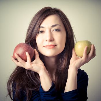 beautiful woman with red and yellow apples on gray background
